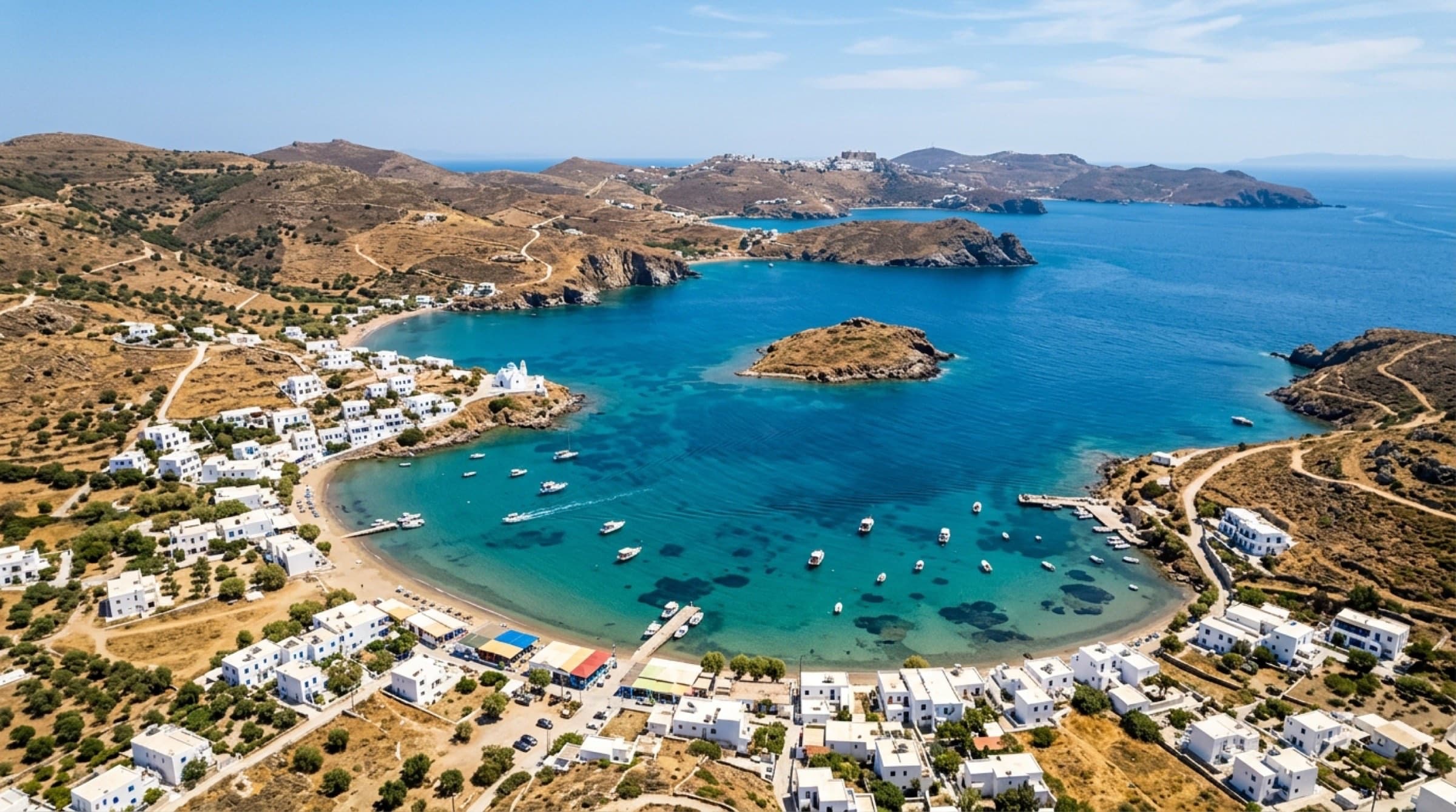 Grikos Bay from above — the curve of the bay, Tragonisi islet, fishing boats